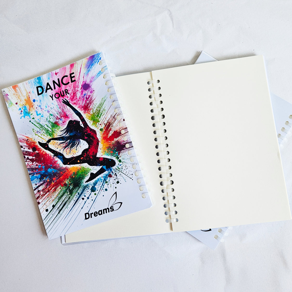 ---NEW---מחברת אימונים בעטיפת פלסטיק צבעונית עם איור של רקדנית קופצת. להתעמלות, אקרובטיקה ומחול. מבית דרימס ג'ימנסטיקס