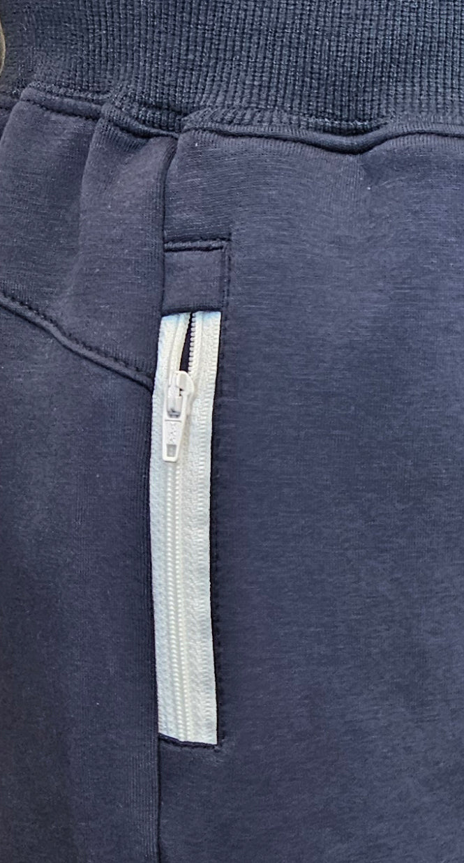 חליפת ספורט מבד עמיד לרוח, מושלם כשכבה שנייה בימים קרים. צבע כחול כהה עם עיצוב עדין ואלגנטי. מבית דרימס ג'ימנסטיקס